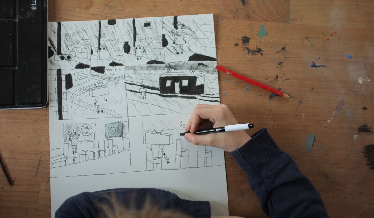 Bild eines Kinder am Zeichnen eines Comics