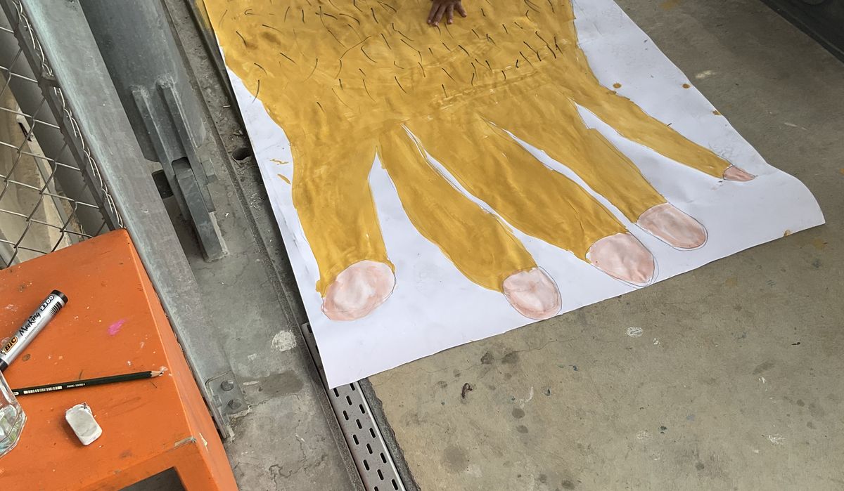 Ein Kind malt die Hand des Riesens.
