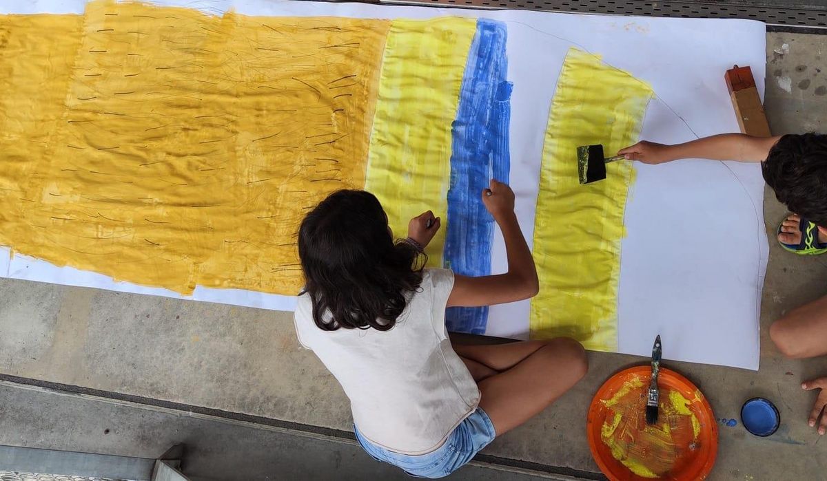 Die Kinder malen die Hand des Riesen
